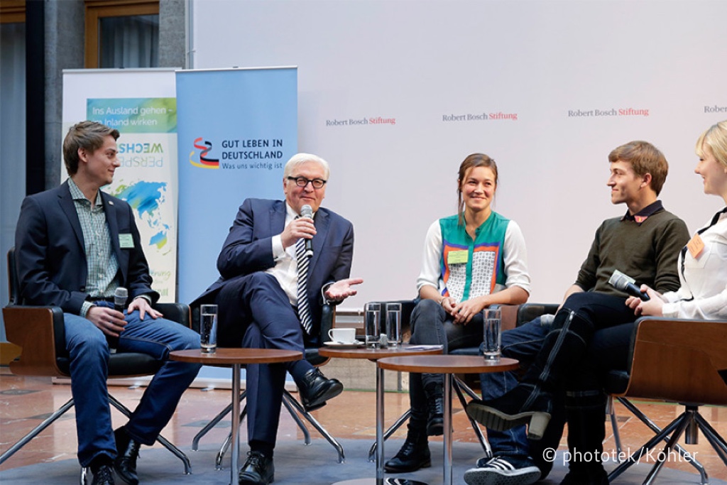 Foto von Frank-Walter Steinmeier, der mit vier Teilnehmern in einem Halbkreis sitzt und mit ihnen diskutiert.