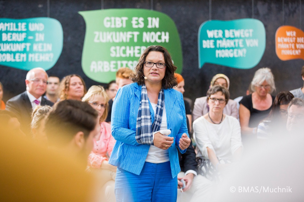 Foto von Andrea Nahles, die in einer Gruppe von Teilnehmern steht.